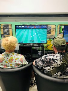 zwei Personen auf Couchsesseln schauen sich das Fußballspiel am Fernseher an