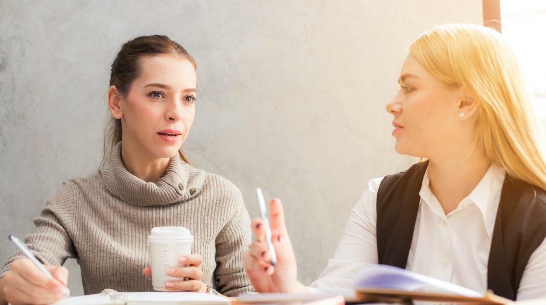 zwei Damen besprechen miteinander etwas im Büro