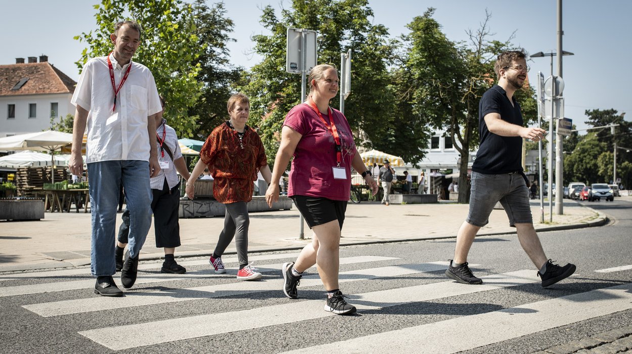 fünf Mobilitätstrainer gehen über den Zebrastreifen