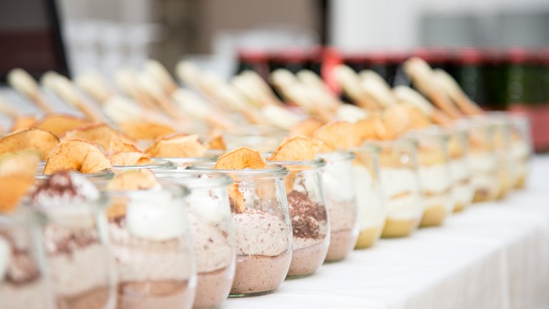 Gläser mit unterschiedlichen Vor- und Nachspeisen auf einem Buffettisch