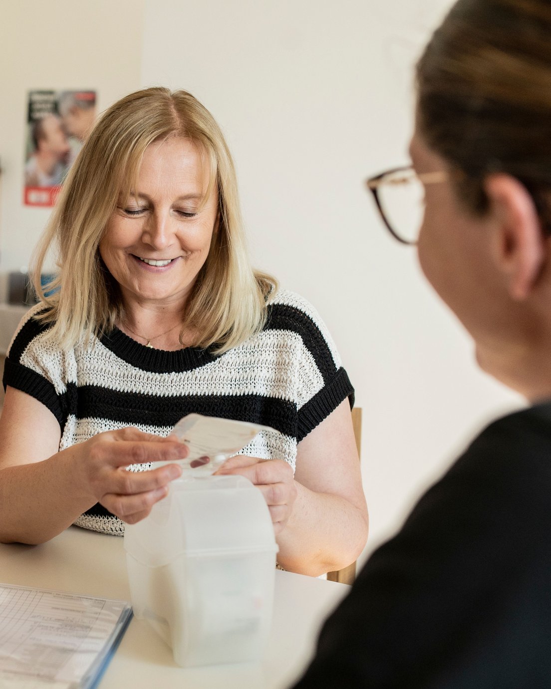 Eine Frau hält einen Stoffbeutel mit Medikamenten in der Hand.