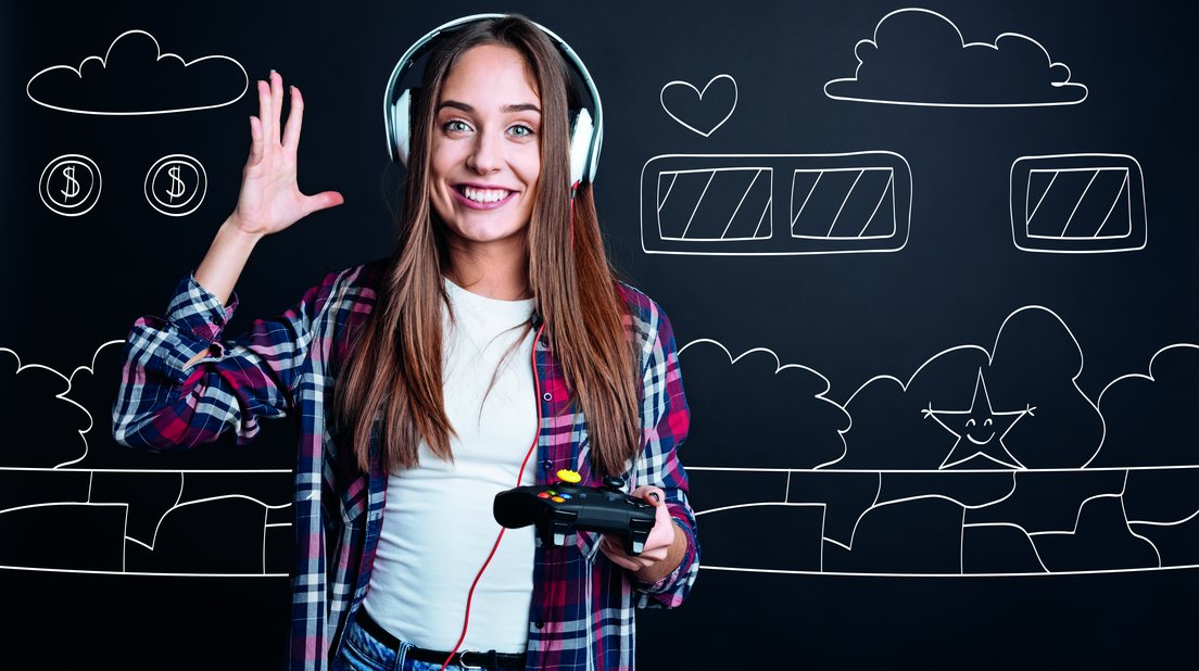 eine Jugendliche hat Kopfhörer auf, eine Spielekonsole in der Hand und ist bereit zu gamen